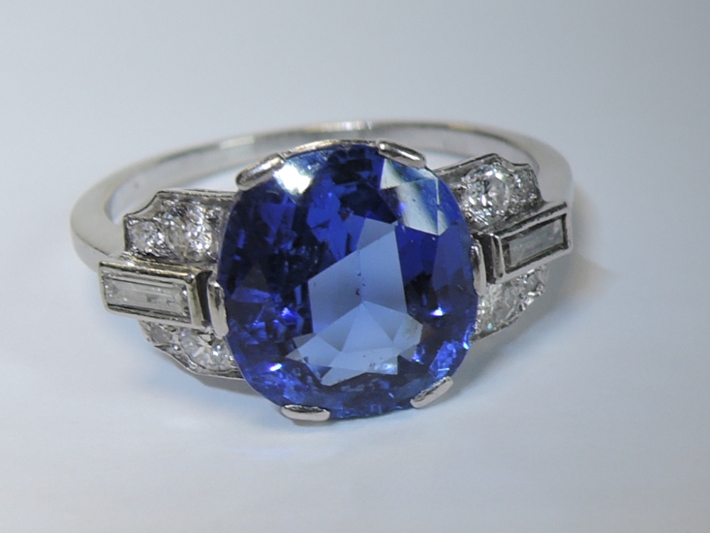 A lady's 1950's dress ring having a large central sapphire, approx 4ct in a six claw setting flanked