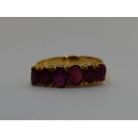 A lady's dress ring having six graduated oval rubies in a claw set gallery mount on a yellow metal