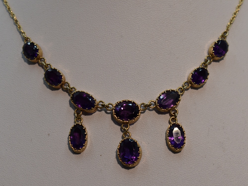 A ten stone heat treated amethyst necklace having seven graduated stones with three drops on a fixed - Image 3 of 4