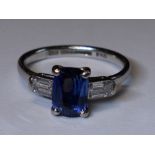 A lady's 1930's dress ring having a central cushion cut sapphire, approx 1.65ct flanked by two