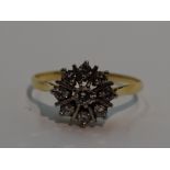 A lady's dress ring having a diamond star burst cluster, approx 0.5ct on a yellow metal loop, no