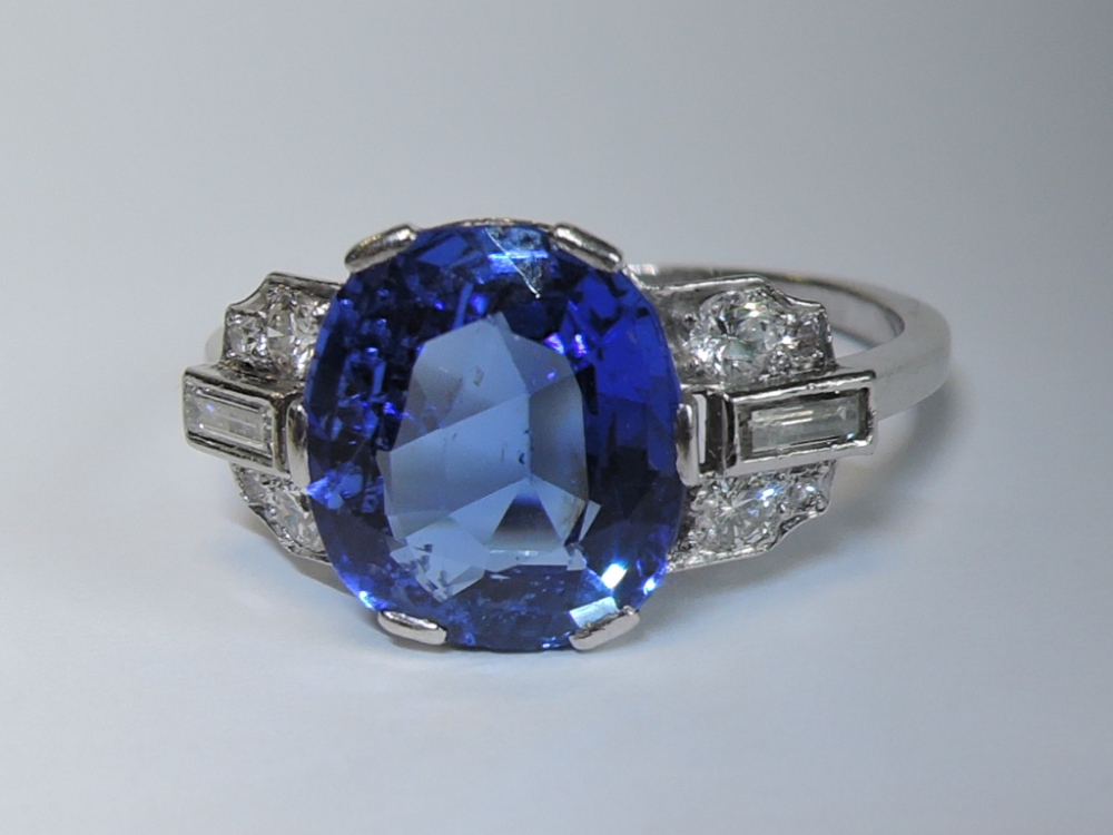 A lady's 1950's dress ring having a large central sapphire, approx 4ct in a six claw setting flanked - Image 2 of 4