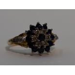 A lady's dress ring having a sapphire and diamond triple cluster to open raised shoulders on an 18ct