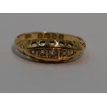 A lady's dress ring having five graduated diamond chips in a gallery mount on an 18ct gold loop,