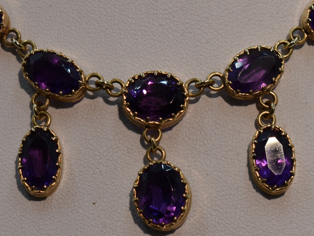 A ten stone heat treated amethyst necklace having seven graduated stones with three drops on a fixed - Image 2 of 4