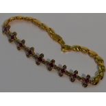 An Oriental ruby and diamond bracelet modelled as a string of four petal interlinked flowers on a