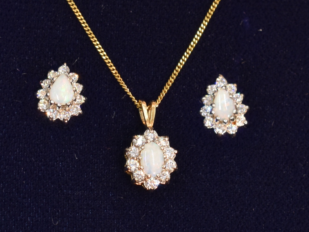 An opal and cubic zirconia oval cluster pendant on a 9ct gold chain, approx 17' with matching stud