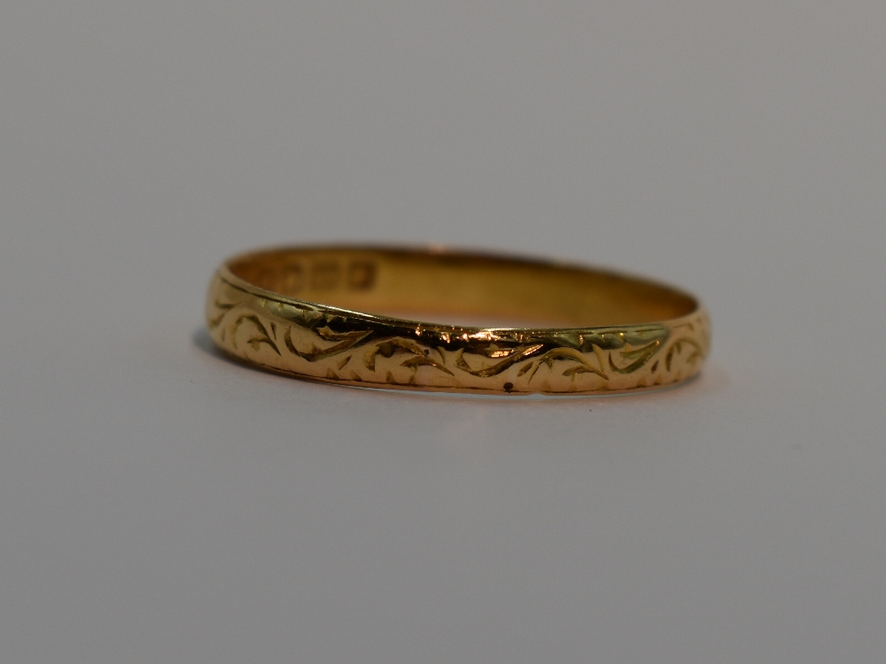 A 22ct gold wedding band having engraved scroll decoration, size V & 3.2g