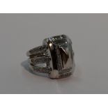 A lady's 18ct white gold dress ring by Mouawad having a large central moulded panel with diamond