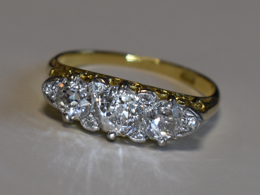 A Victorian lady's dress ring having three graduated diamonds with a border of six diamond chips,