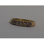 A lady's dress ring having five diamonds in a claw set raised mount on an 18ct gold loop, size M