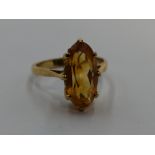 A lady's dress ring having a lozenge shaped citrine in a claw set basket mount on a yellow metal