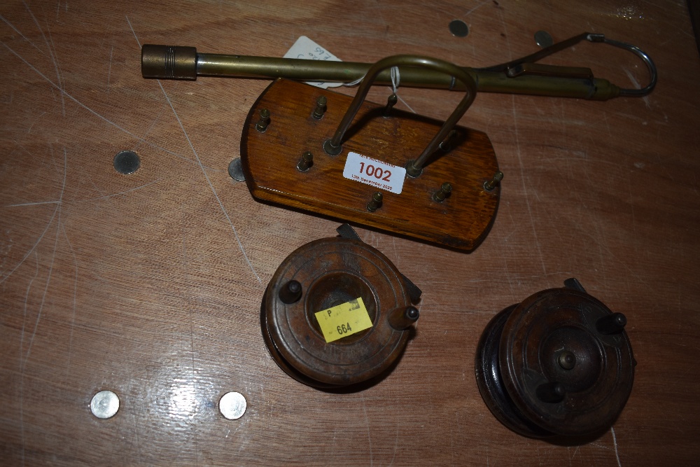 An assortment of antique fishing tackle including two wooden reels and an extending brass gaff.