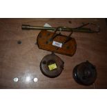 An assortment of antique fishing tackle including two wooden reels and an extending brass gaff.