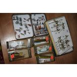 A collection of wooden and quill lures and a tin of flies.