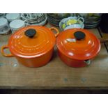 Two orange enamel Le Creuset lidded cooking pans