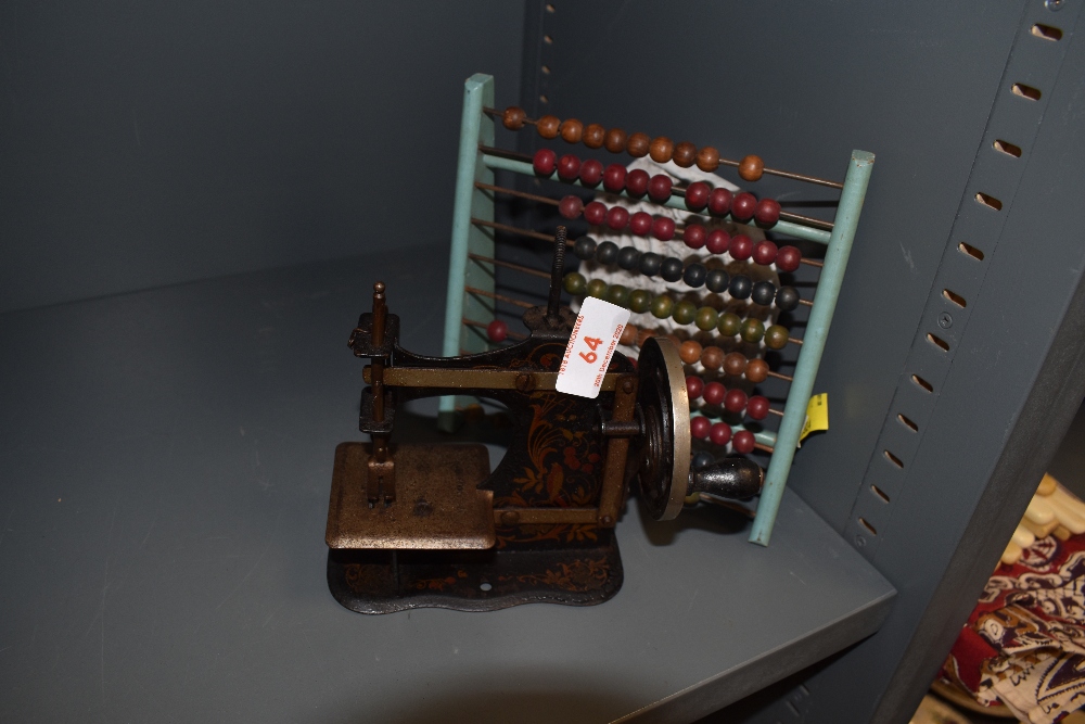 A vintage wooden abacus and miniature late Victorian sewing machine.