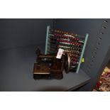 A vintage wooden abacus and miniature late Victorian sewing machine.