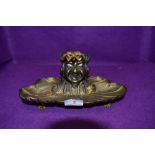A late 19th/early 20th century gilded bronze gents desk top ink well having grotesque squatting
