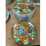 A tin of collectable/erotic retro pin badges.