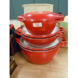 A set of graduated cast and enamel Creuset style casserole pans in red