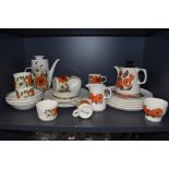 A selection of retro ceramics having vibrant orange floral patterns, one being Barker Bros Orange