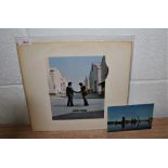 A copy of Wish you were Here by Pink Floyd with the postcard