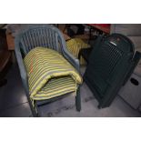 A selection of green plastic garden chairs and complementary cushions