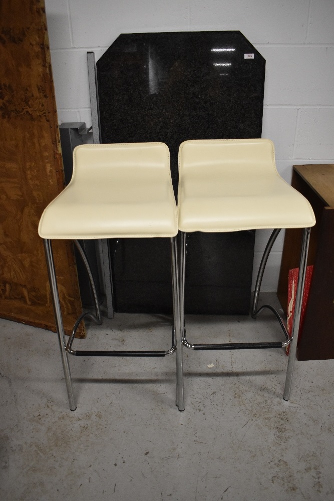 A modern granite breakfast bar and two modern stools