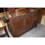 A period oak mule chest having carved frieze, three panel top section over double drawer base,