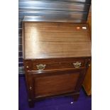 An early 20th Century mahogany and inlaid bureau, having cupboard base