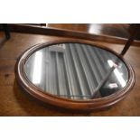 A late 19th/early 20th Century oval wall mirror, ex dressing table