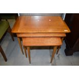 A vintage teak nest of three tables, on tapered legs