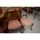 A pair of mahogany balloon back dining chairs, repair to backs