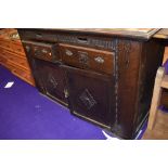 An early 20th Century oak sideboard , having interesting frieze drawers and additional 'wings' ,