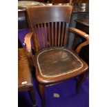 A n early 20th Century stained frame office armchair with leather studded seat