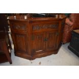 A nice quality Old Charm or similar canted side cabinet having linen fold doors, labelled on back