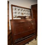 A late 19th/early 20th Century mahogany panelled bed frame, including side irons and base, width