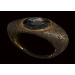 A large late roman gilted bronze ring set with a glass paste.