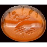 A roman carnelian intaglio. Dextrarum junctio with letters.