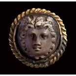 A roman agate cameo mounted in an ancient gold brooch. Medusa mask.