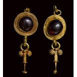 A pair of roman gold earrings set with garnets.