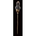 A banded agate female bust set in a gold stick pin.