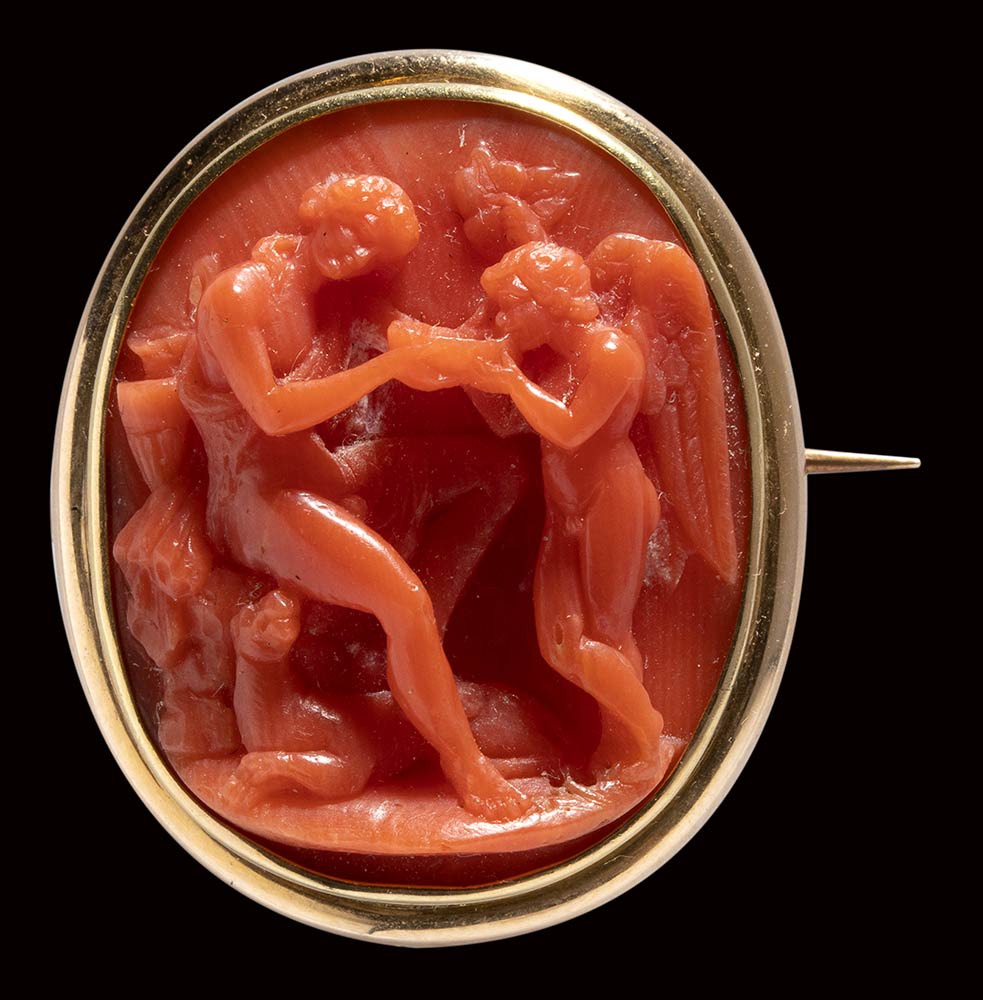A fine red coral neoclassical cameo set in a gold brooch. Bacchus and Cupid.