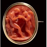 A fine red coral neoclassical cameo set in a gold brooch. Bacchus and Cupid.