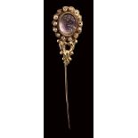 A postclassical amethyst cameo set in a gold stick pin with pearls. Bust of Cupid.