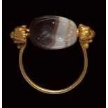 An etruscan banded agate scarab intaglio mounted on an gold ring. Horned stag running.