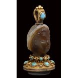 A fine banded agate seal set in a gold mounting with turquoise. Female head.