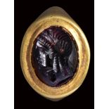 An fine hellenistic garnet intaglio mounted on an ancient gold ring. Bust of Isis.