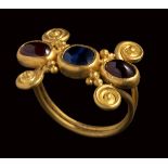A late roman gold ring set with a shappire and two garnets.